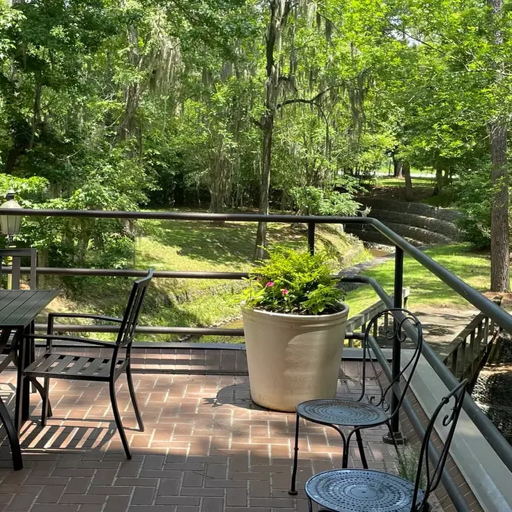 Brick patio with tables under the pines at Rice's Café