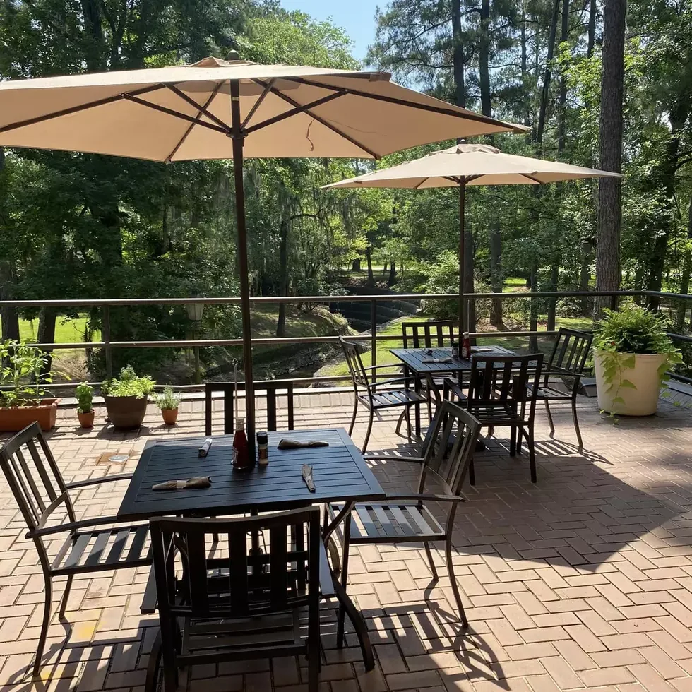 Patio tables with umbrellas under the pines at Rice's Café